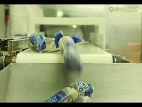 Oyster products in blue packaging moving along a conveyor belt in a seafood processing facility.